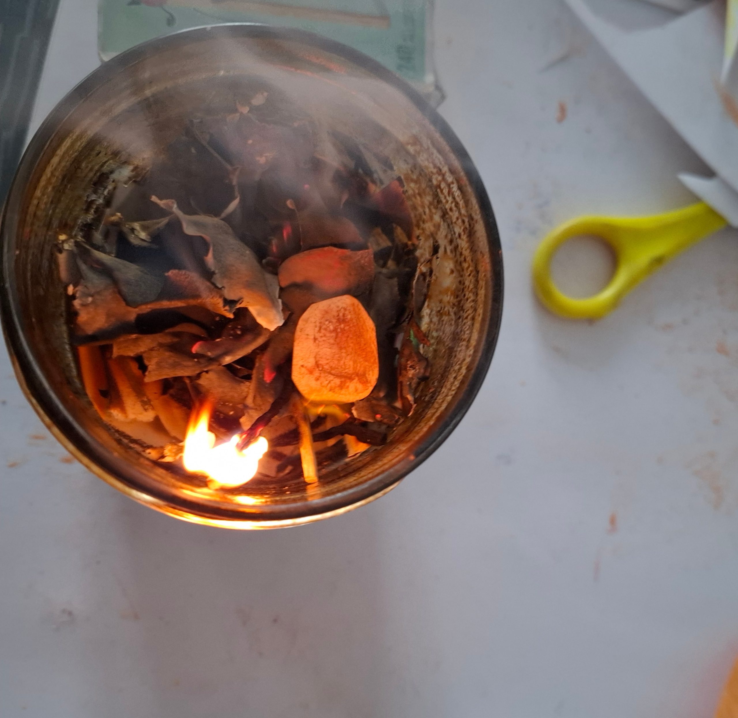 Flamme dans un verre, papier et ciseaux évoquant la transformation créatrice en art-thérapie.